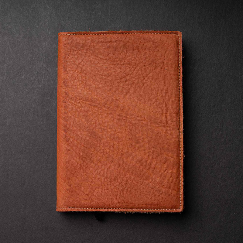 Hand Made Full Grain leather journal cover that comes with a 192 page A5 journal. This journal is handmade and can be personalized with your name or your initials! Made with orange shrunken bison leather.