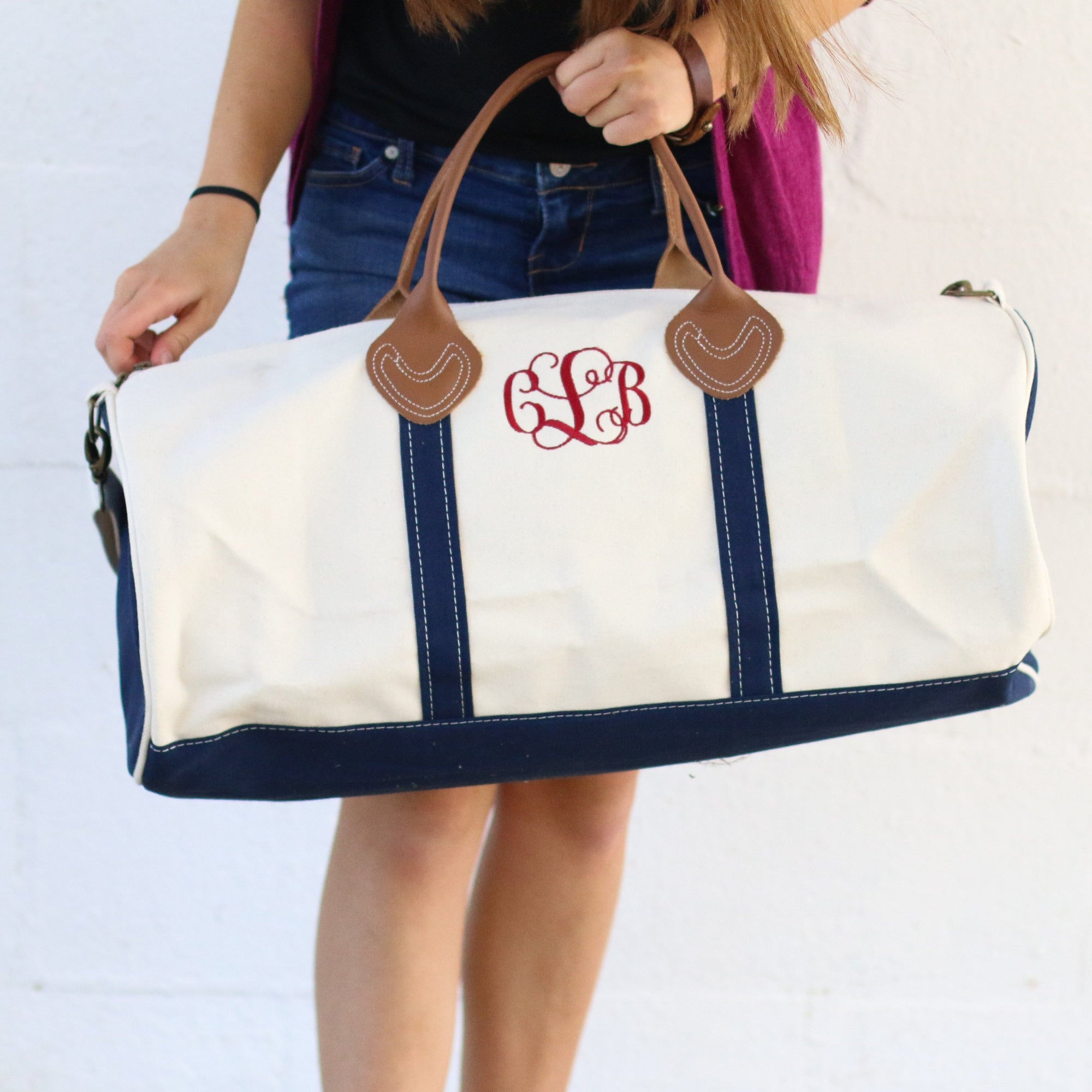 white and navy round duffel bag with personalized initials